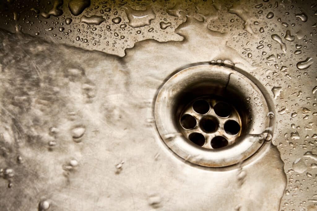 Eau stagnante dans un évier en inox indiquant un bouchon à Amiens
